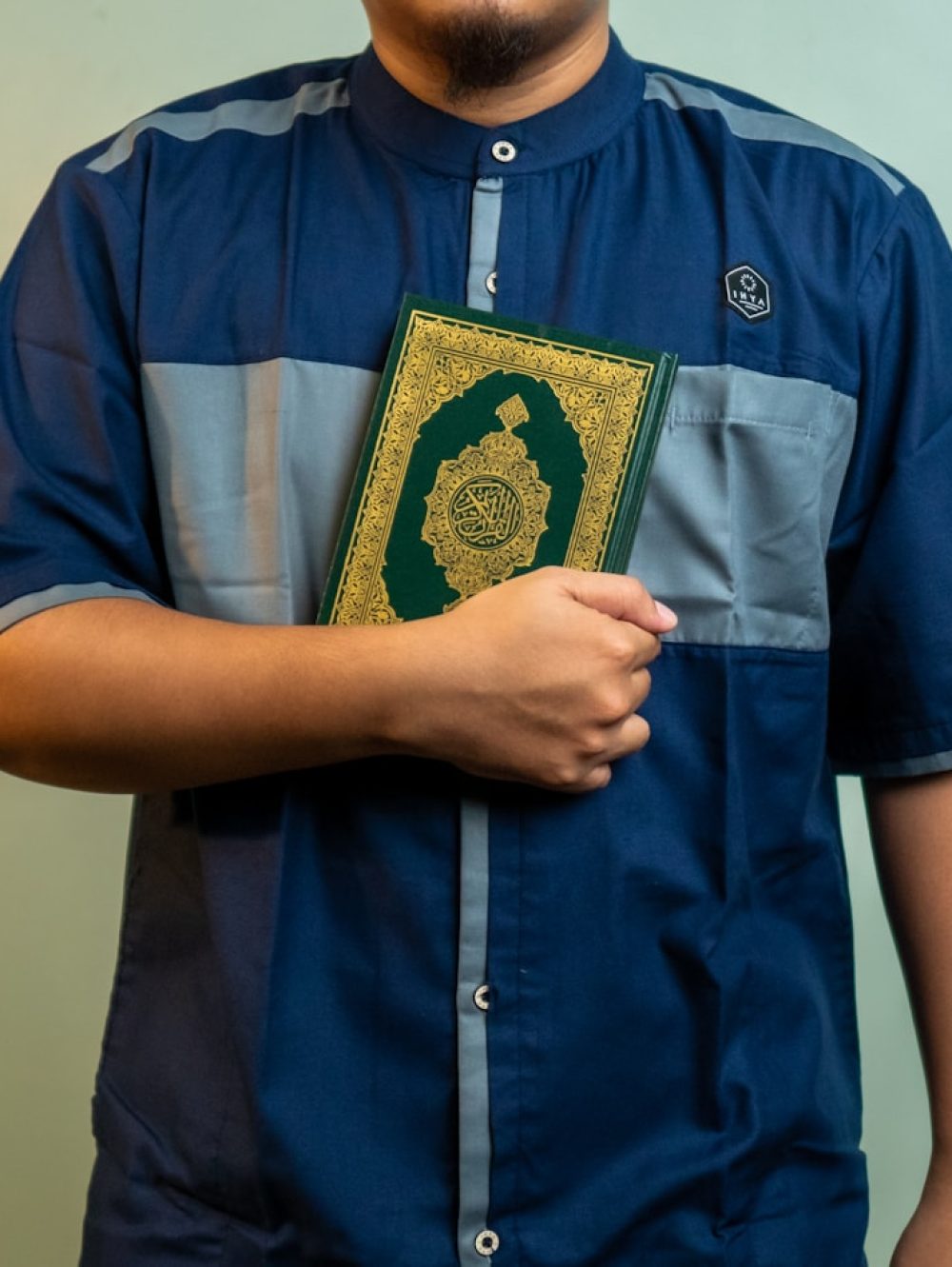 a man wearing a blue shirt with a gold emblem on it